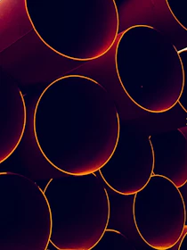 Stack of vibrant orange and white CPVC pipe fittings showcasing different sizes and angles.