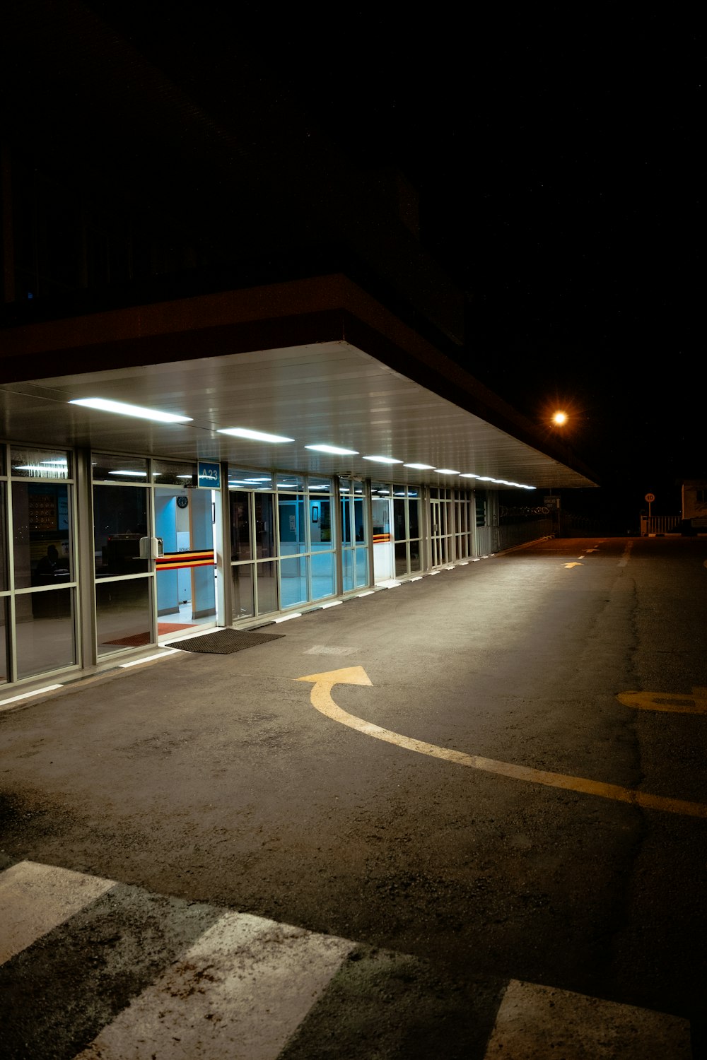 a empty parking lot at night with a bus stop