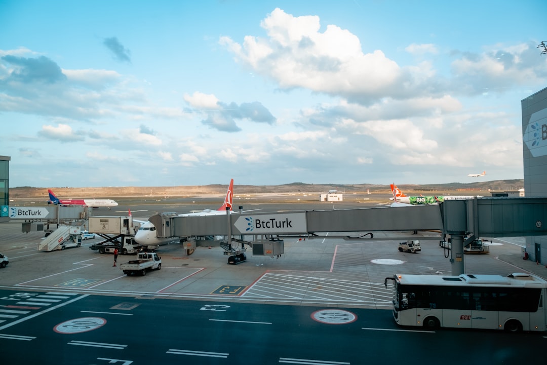 an airport parking lot with a bus parked in front of it,