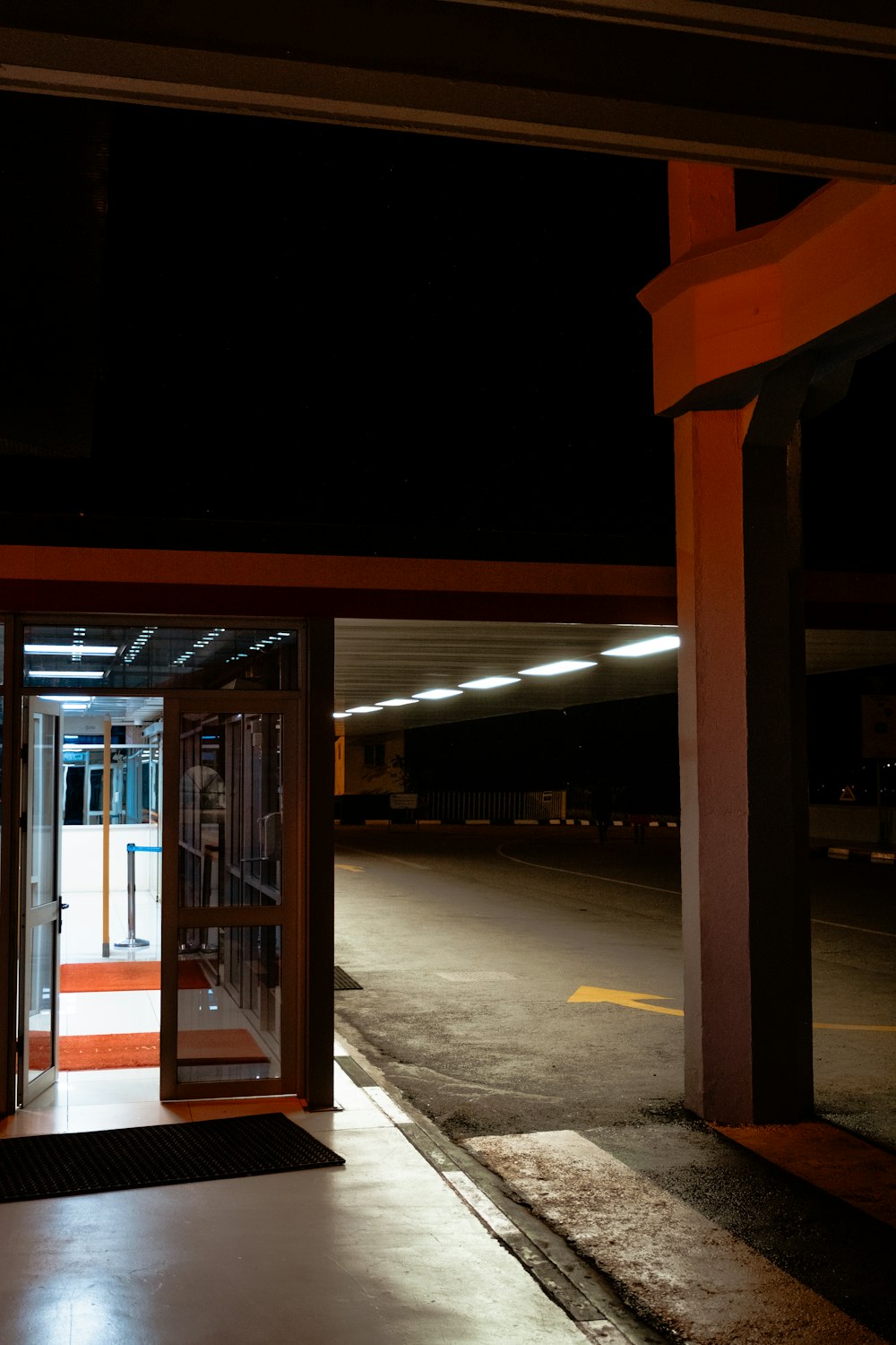 an empty parking lot at night with a door open