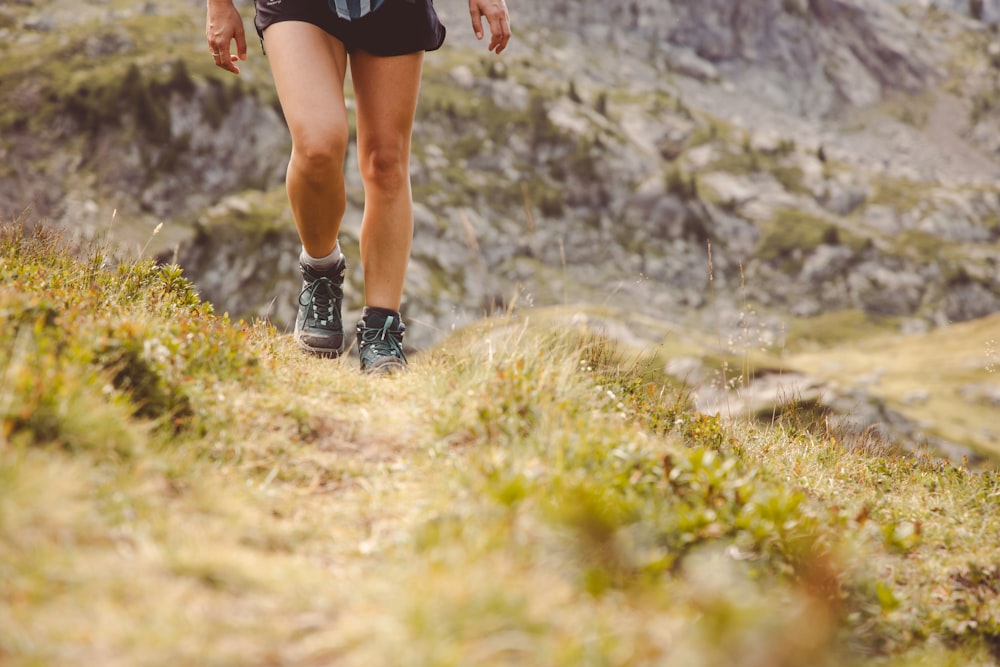 a woman running up a hill in the mountains