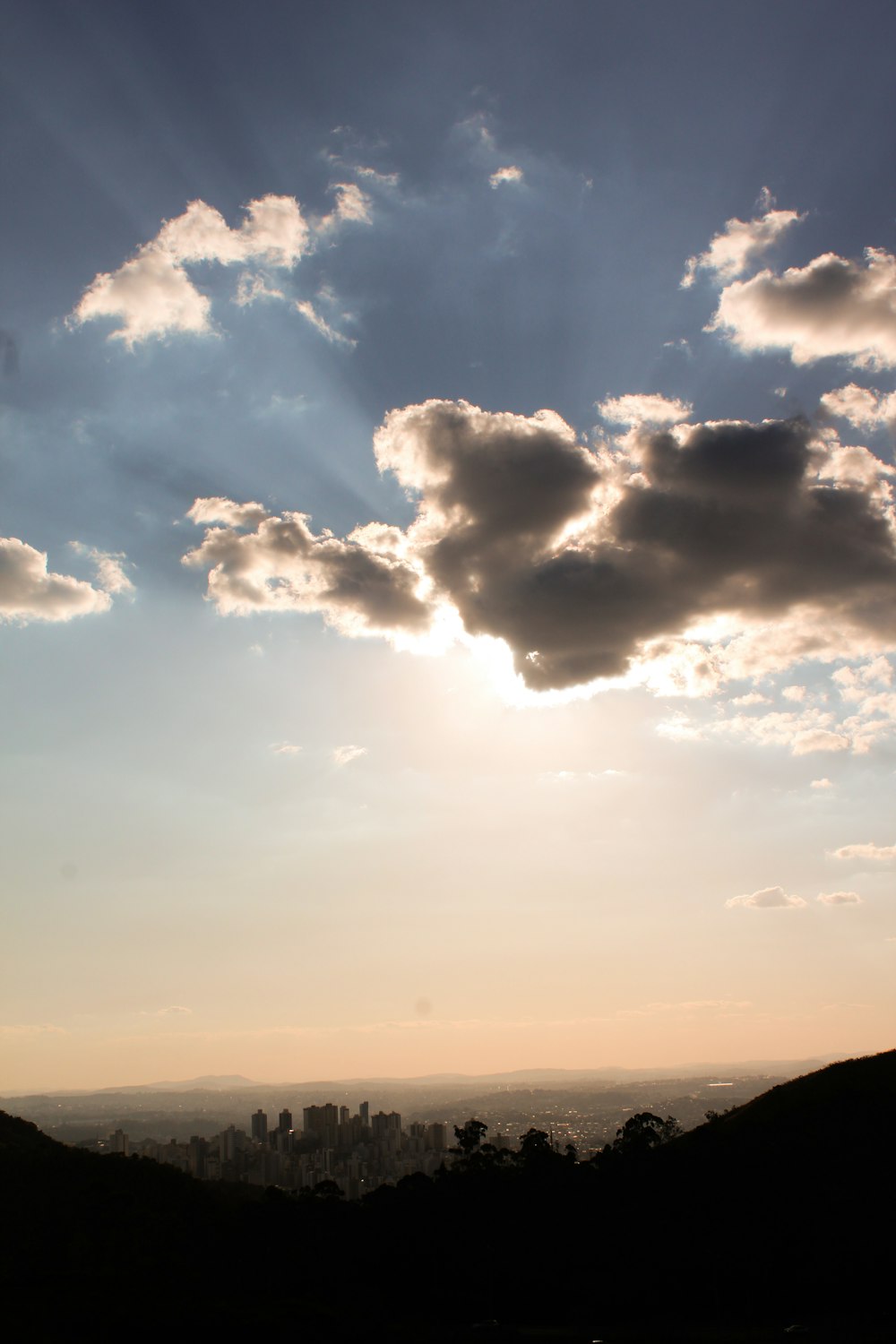 the sun is shining through the clouds over the hills