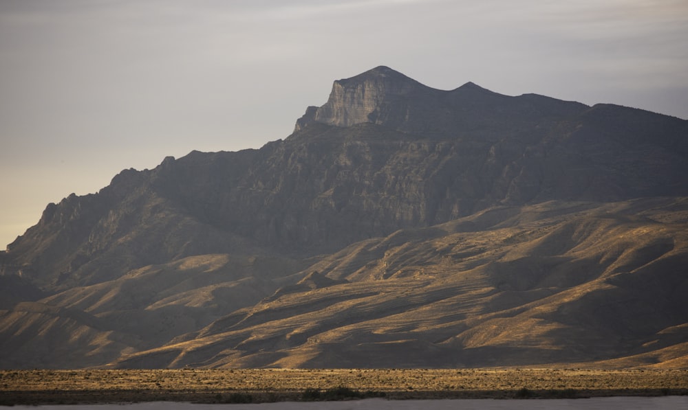 a large mountain with a large body of water in front of it