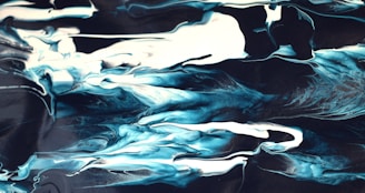An artist painting fluid, blue and green abstract shapes symbolizing water.