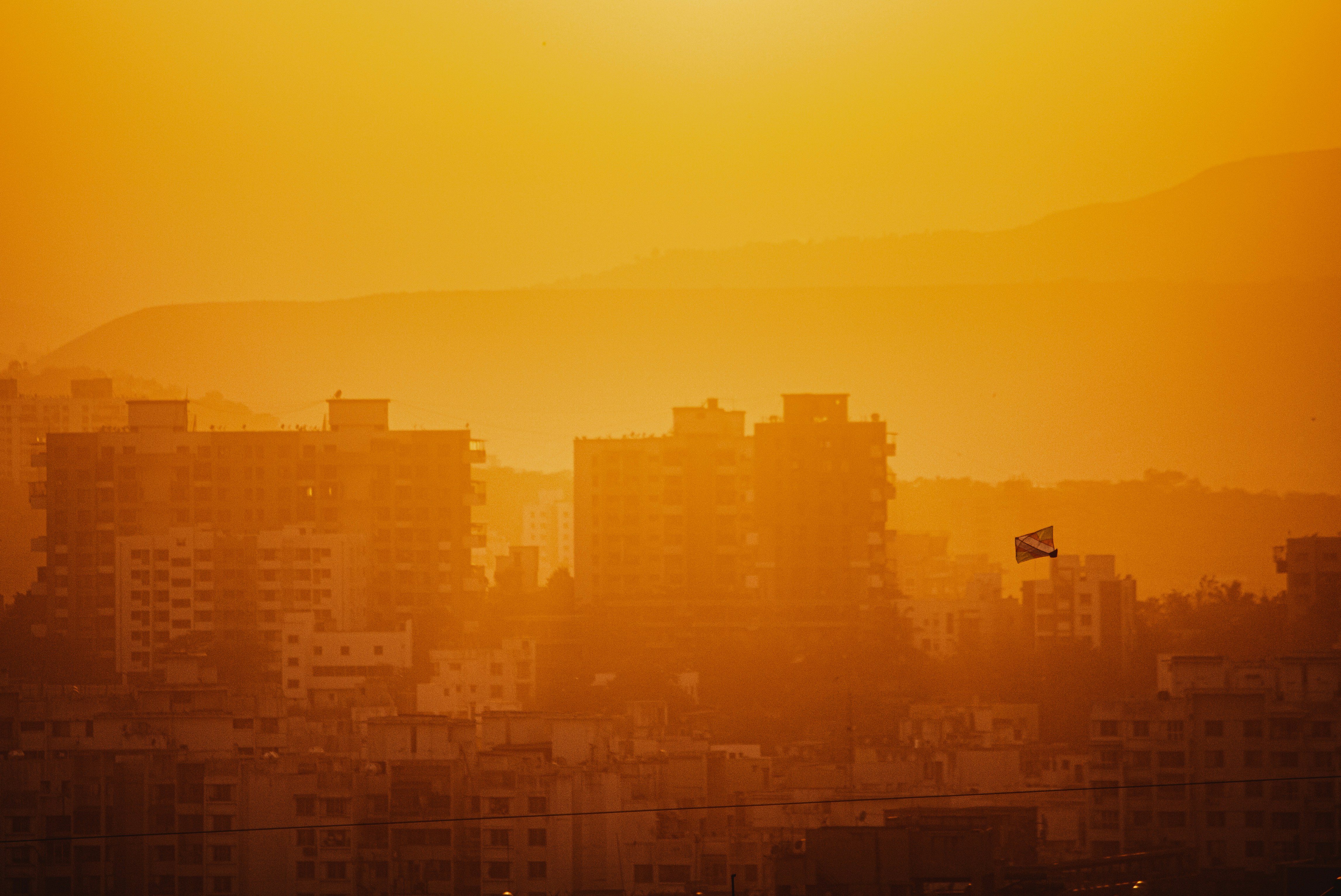 the sun is setting over a city with tall buildings