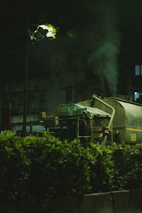 Technician in uniform operating a vacuum truck during nighttime service