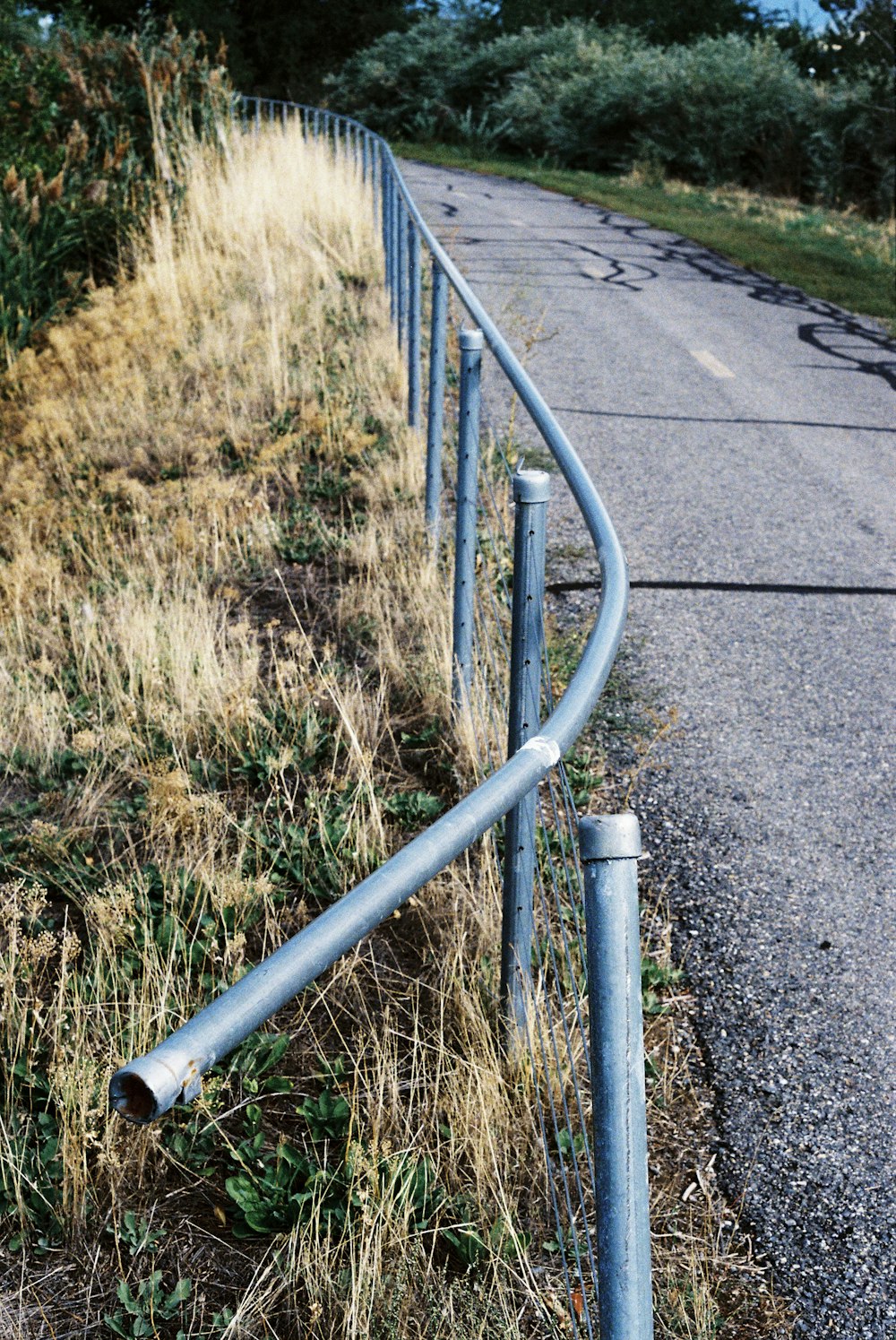 a road with a metal fence on the side of it