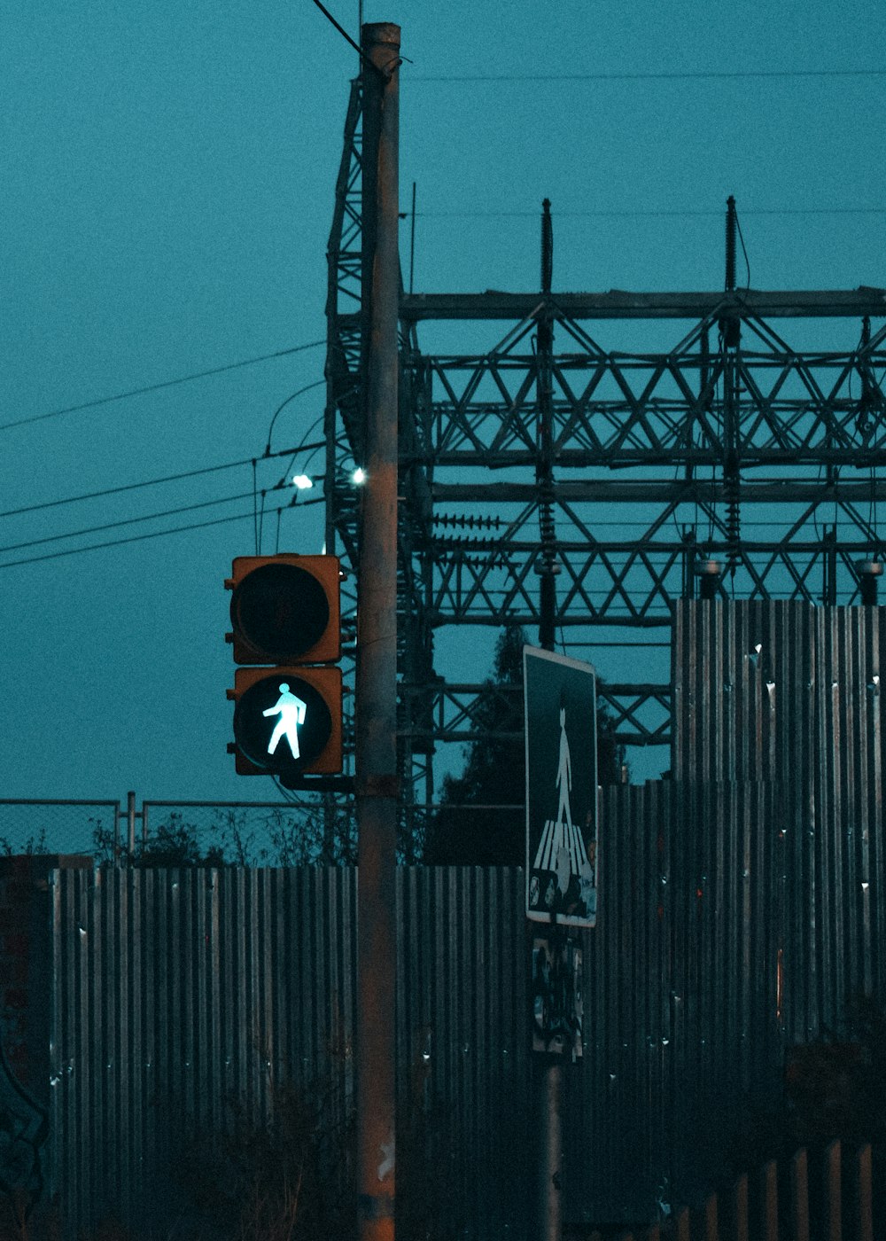a traffic light sitting next to a metal fence