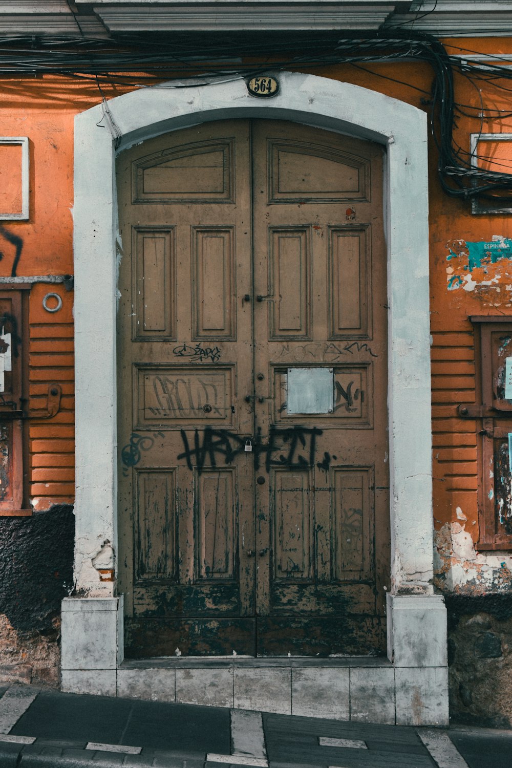 a wooden door with graffiti on the side of a building