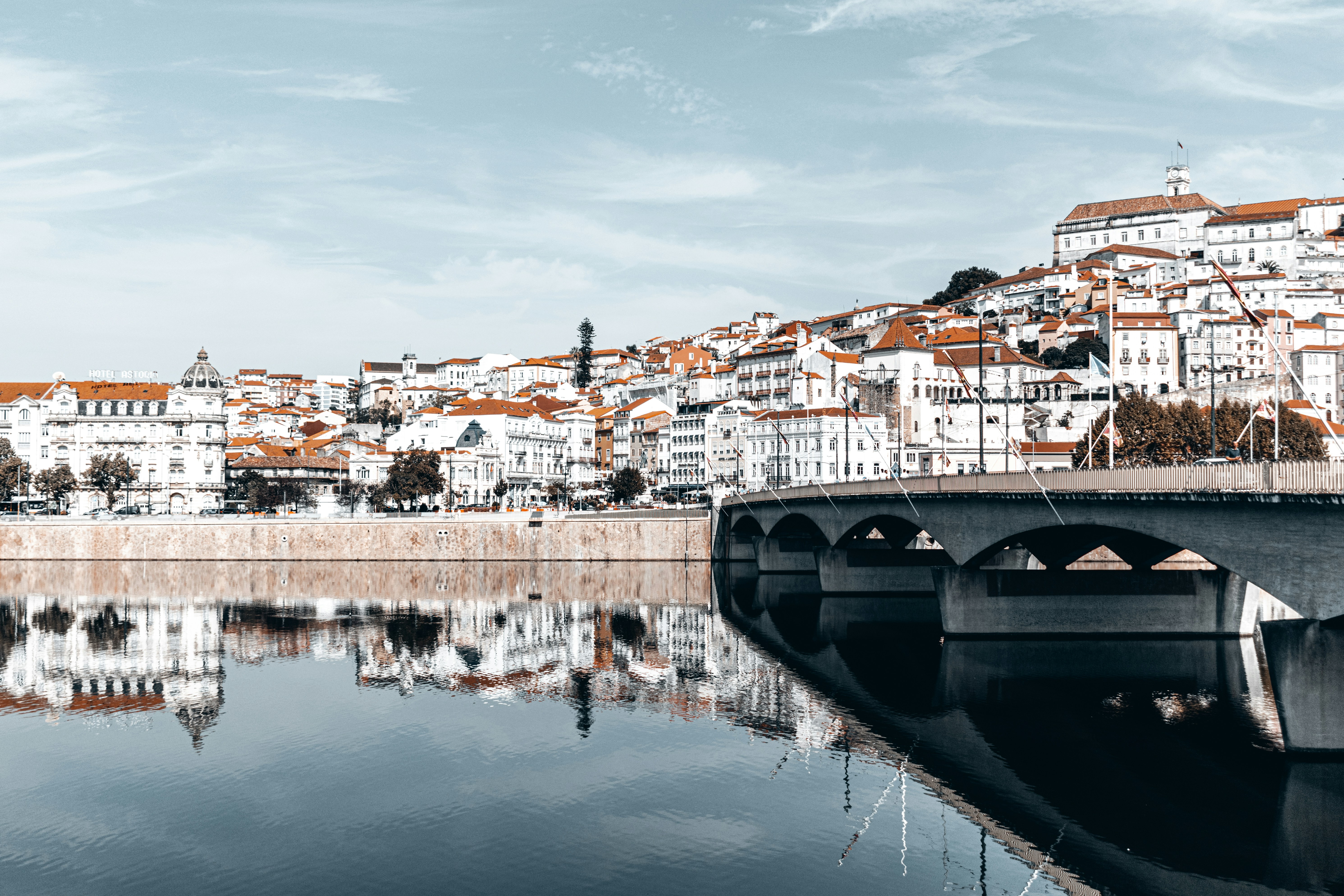 a bridge over a body of water with buildings in the background