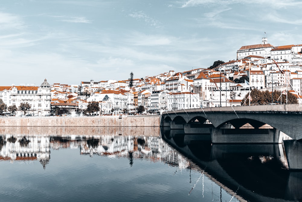 a bridge over a body of water with buildings in the background