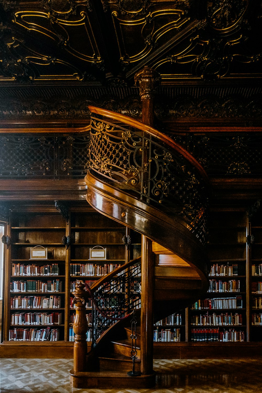 a spiral staircase in a library with bookshelves