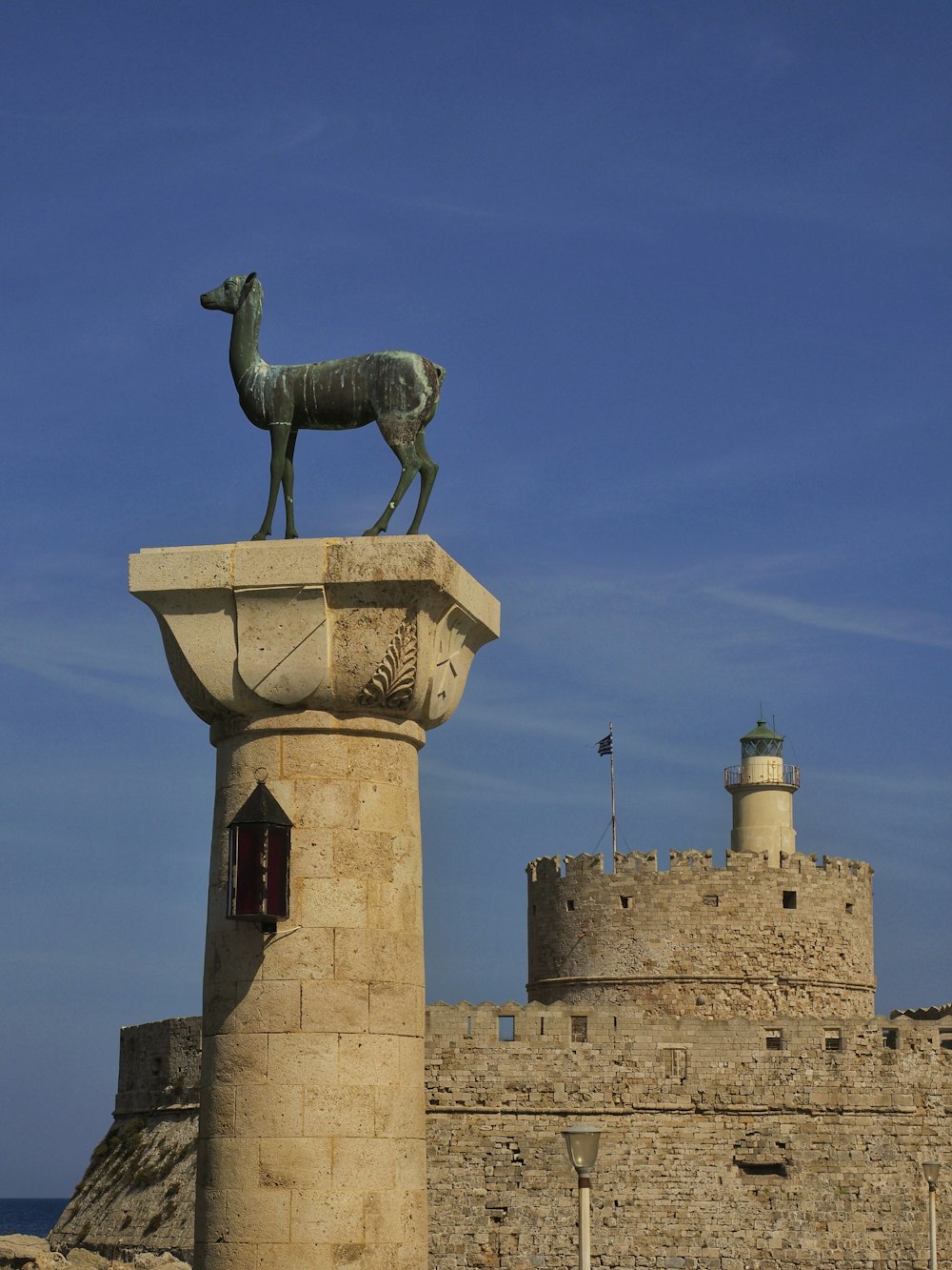 uma estátua de uma cabra no topo de uma torre