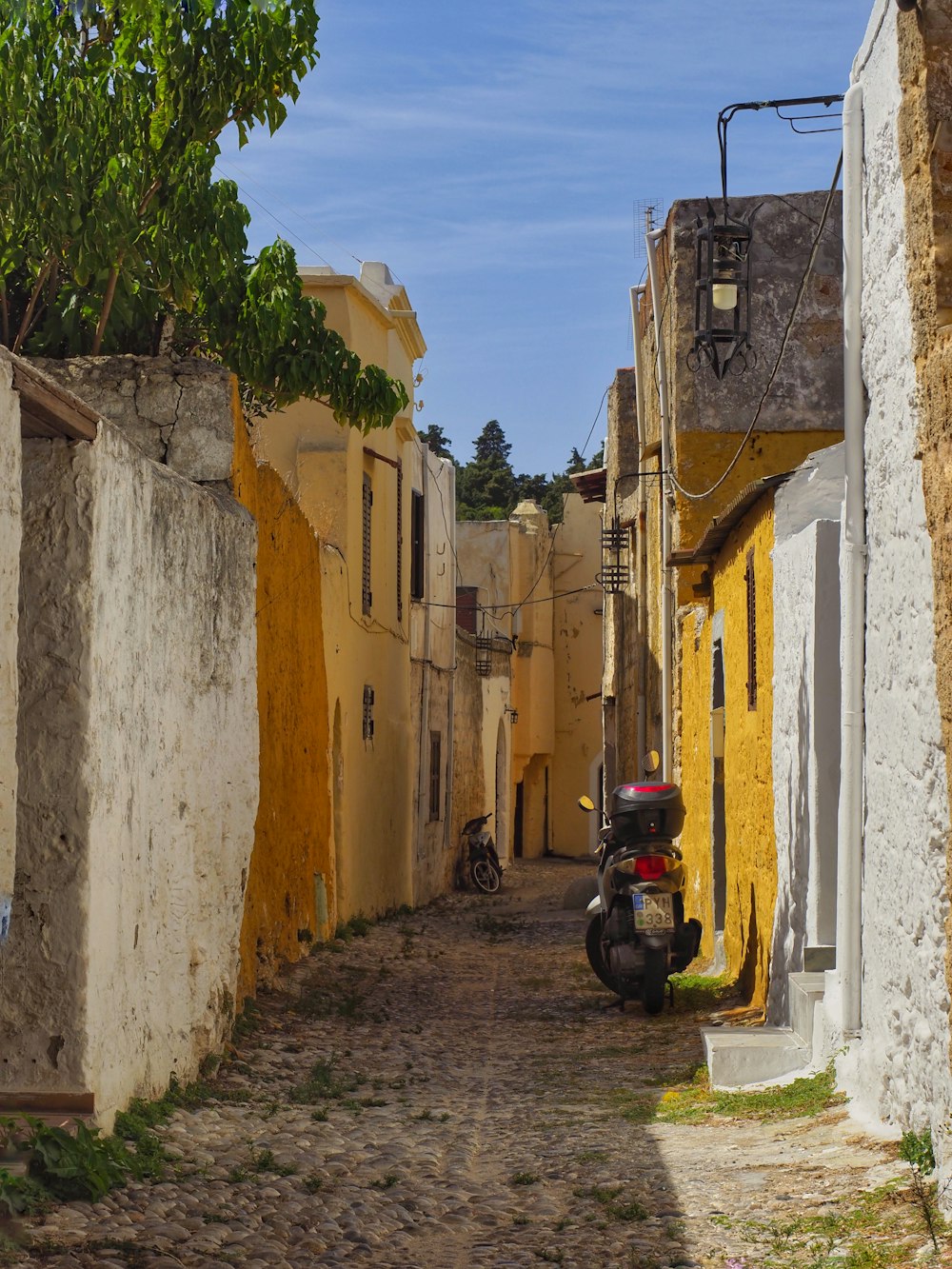 a motor scooter is parked in a narrow alley