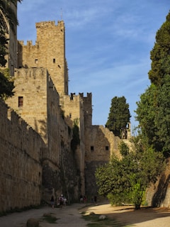 Smiling friends exploring a historic castle surrounded by lush greenery.