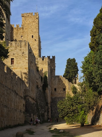 Smiling friends exploring a historic castle surrounded by lush greenery.