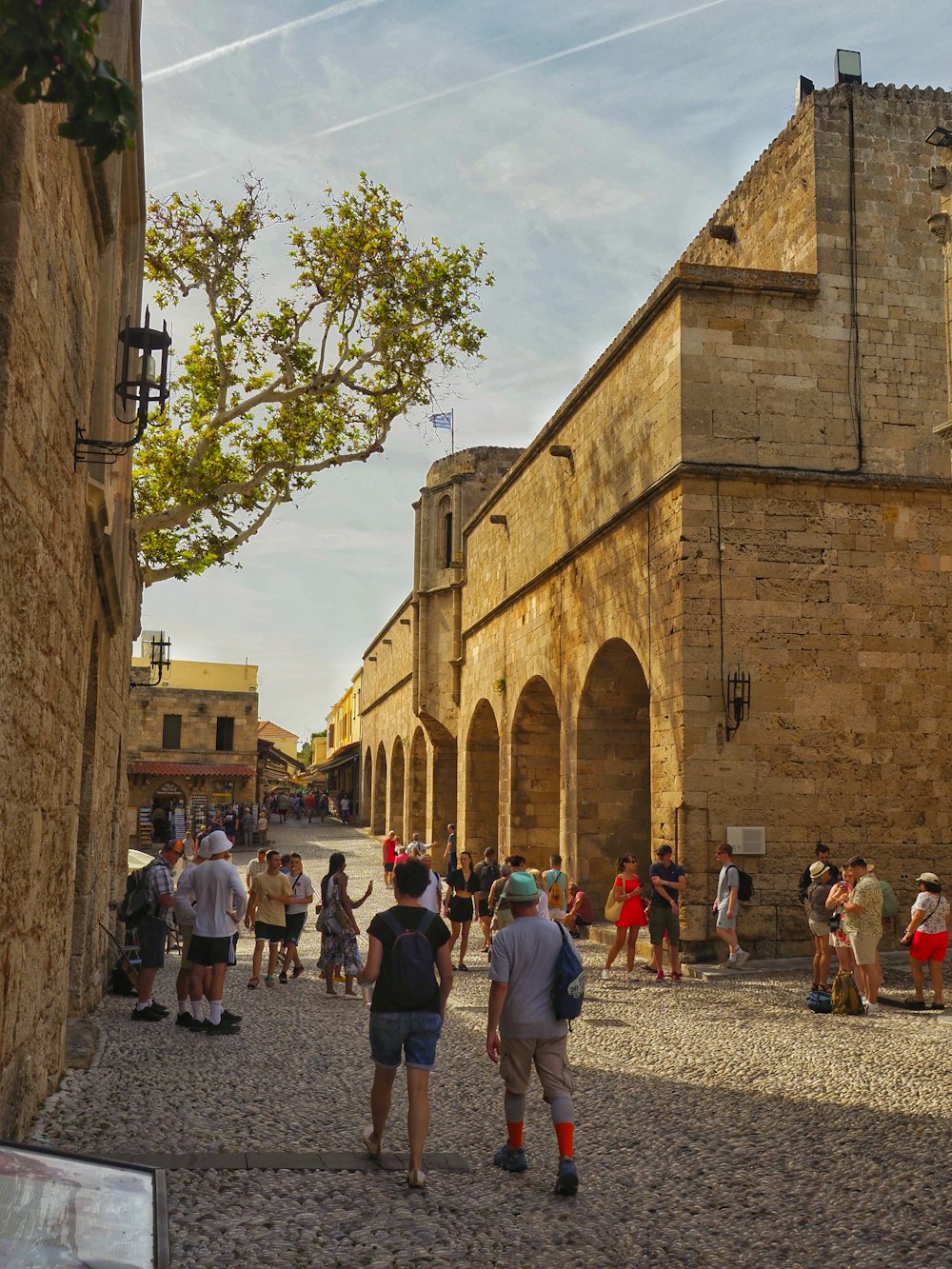 a group of people standing around a stone building