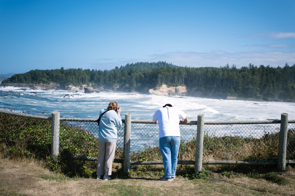 a couple of people that are looking at the water