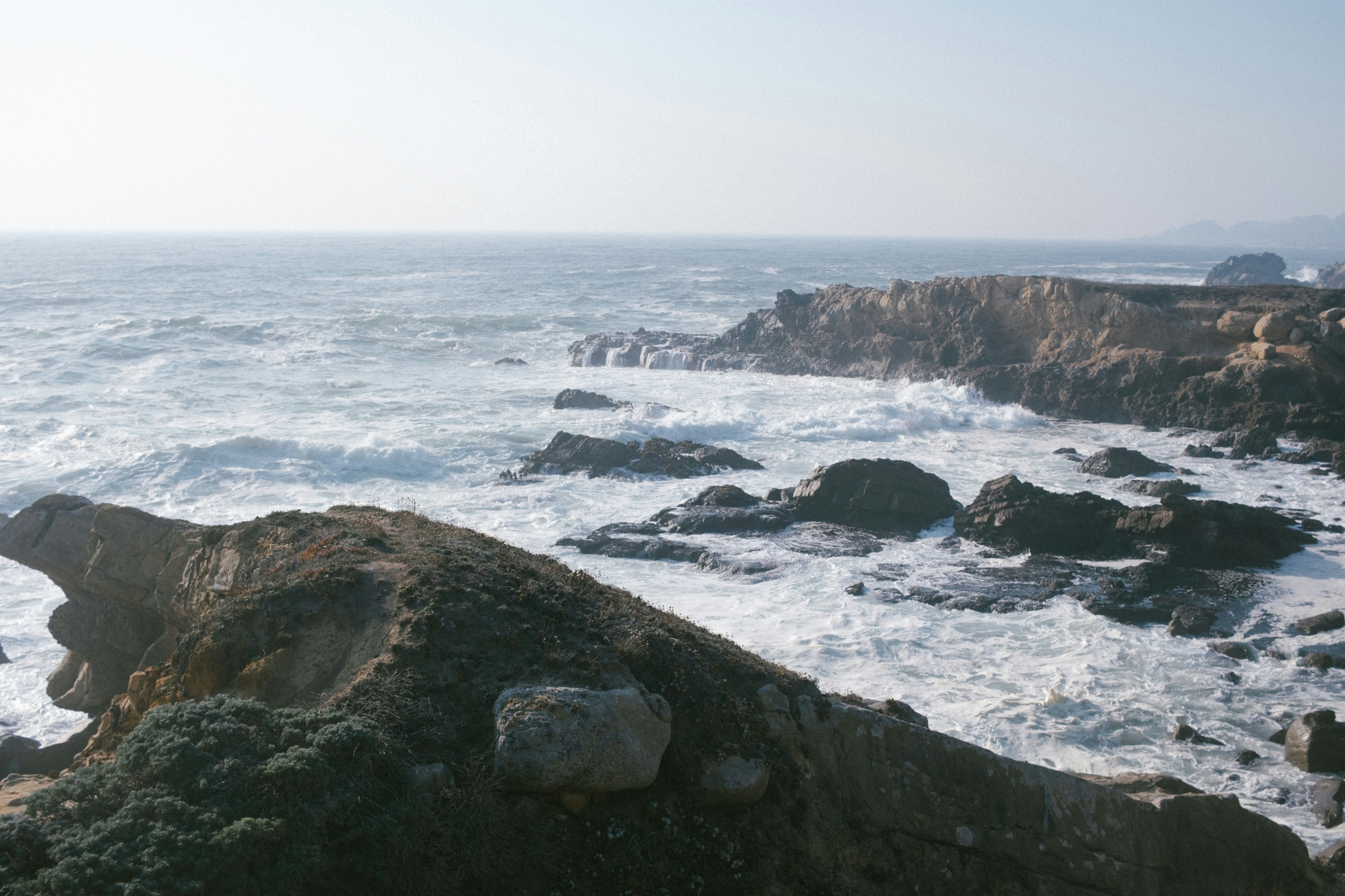 a rocky shore with a large body of water