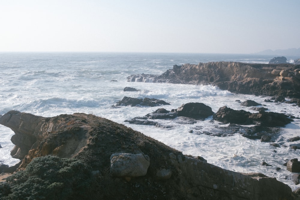 a rocky shore with a large body of water