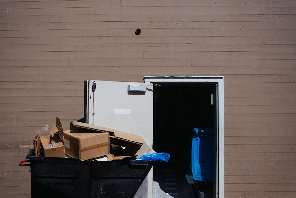 a pile of boxes and other items in a dumpster