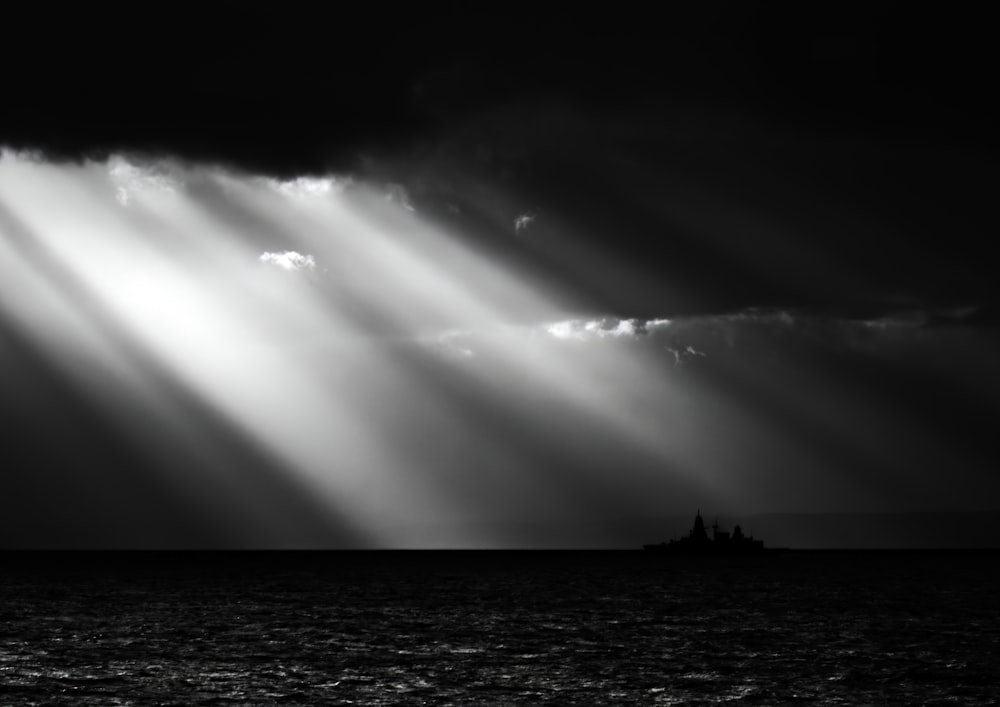 a black and white photo of a boat in the ocean