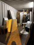A professional mover carefully packing fragile items into sturdy boxes inside a bright, organized home.