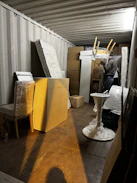 A friendly Am Movers staff member carefully wrapping a vintage wooden chair in protective padding.
