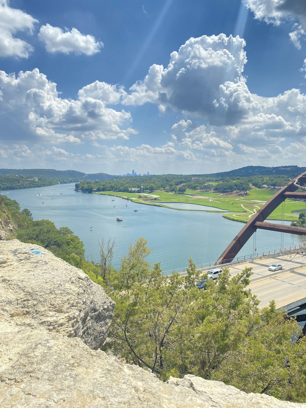 a view of a river and a bridge from a cliff