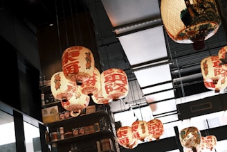 Handcrafted Asian lanterns hanging from the ceiling, casting warm light over the shop.