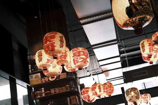 Handcrafted Asian lanterns hanging from the ceiling, casting warm light over the shop.