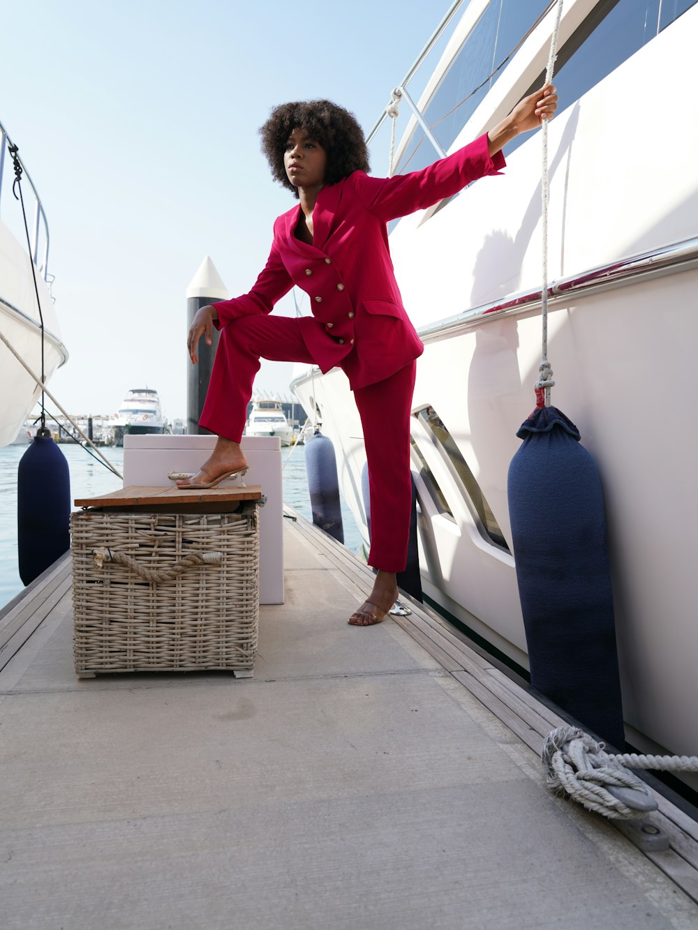 a woman in a red suit standing on a boat