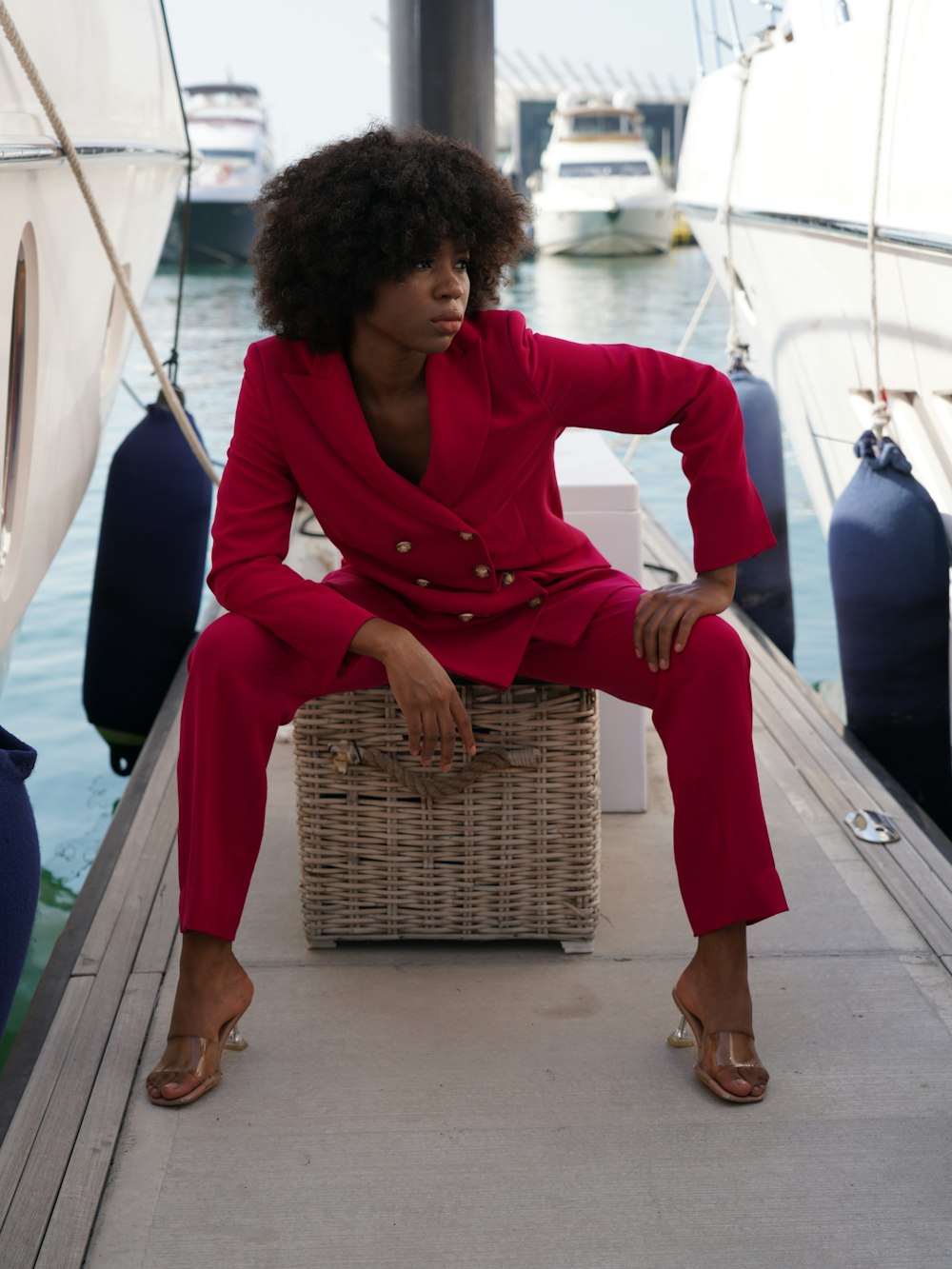 a woman in a red suit sitting on a wicker basket