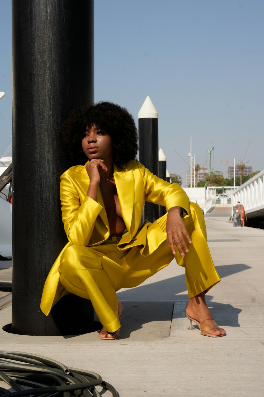 a woman in a yellow suit sitting on a pole