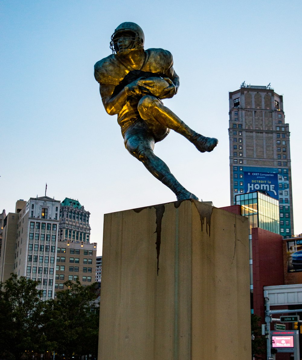 a statue of a football player on a pedestal