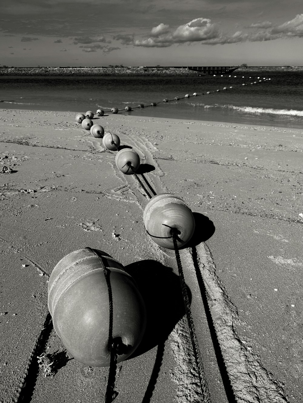 a row of balls sitting on top of a sandy beach