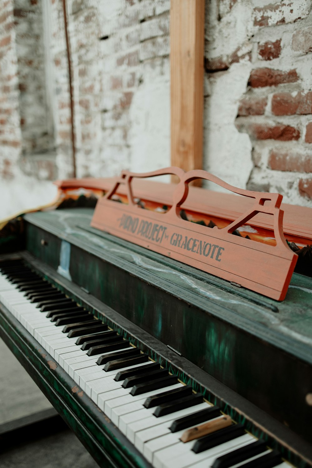 Un primo piano di un pianoforte vicino a un muro di mattoni