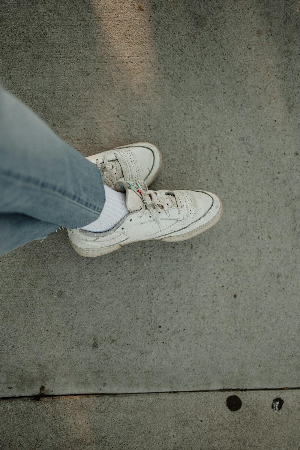 une personne debout sur un trottoir avec ses chaussures
