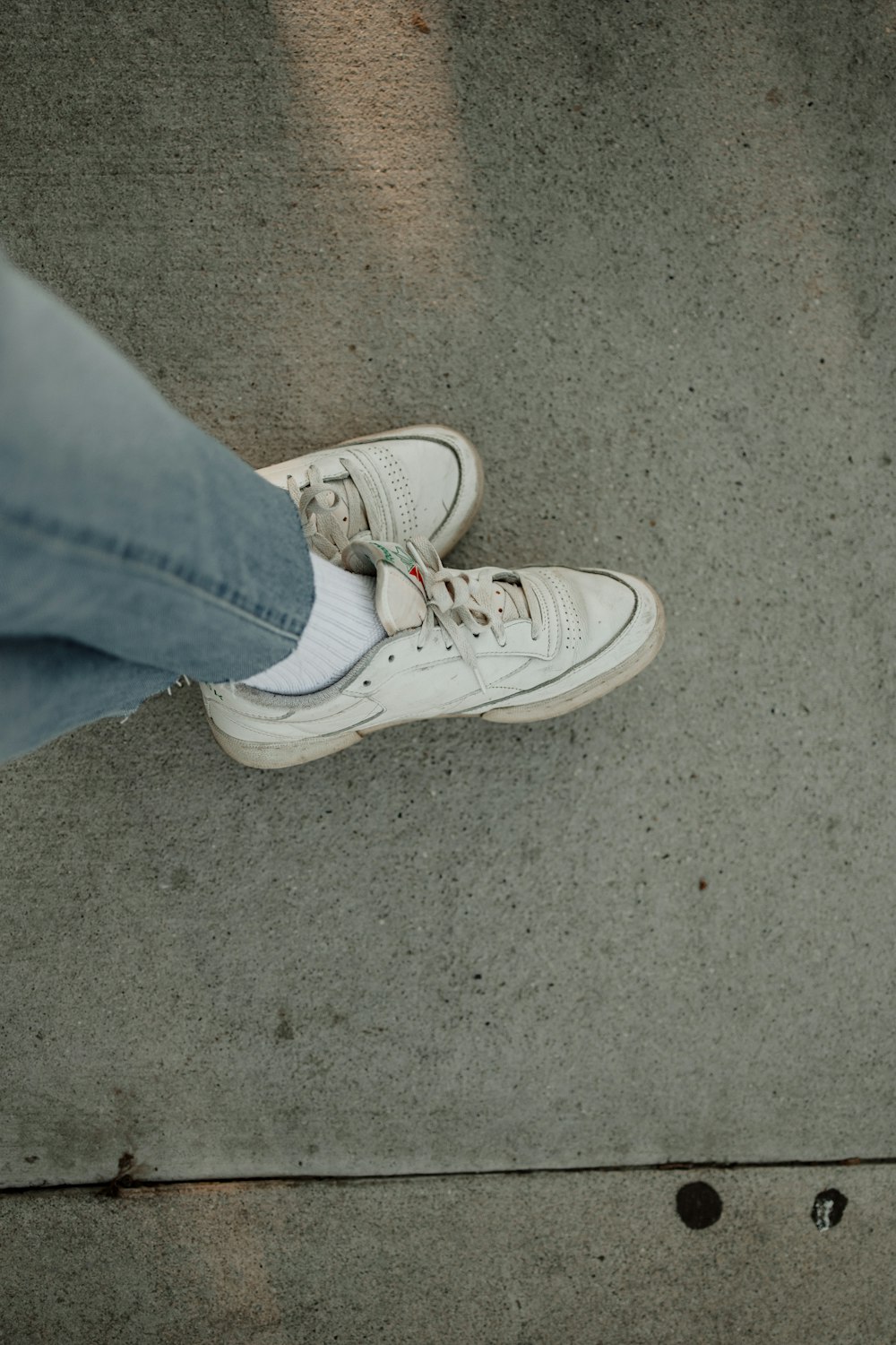 a person standing on a sidewalk with their shoes on