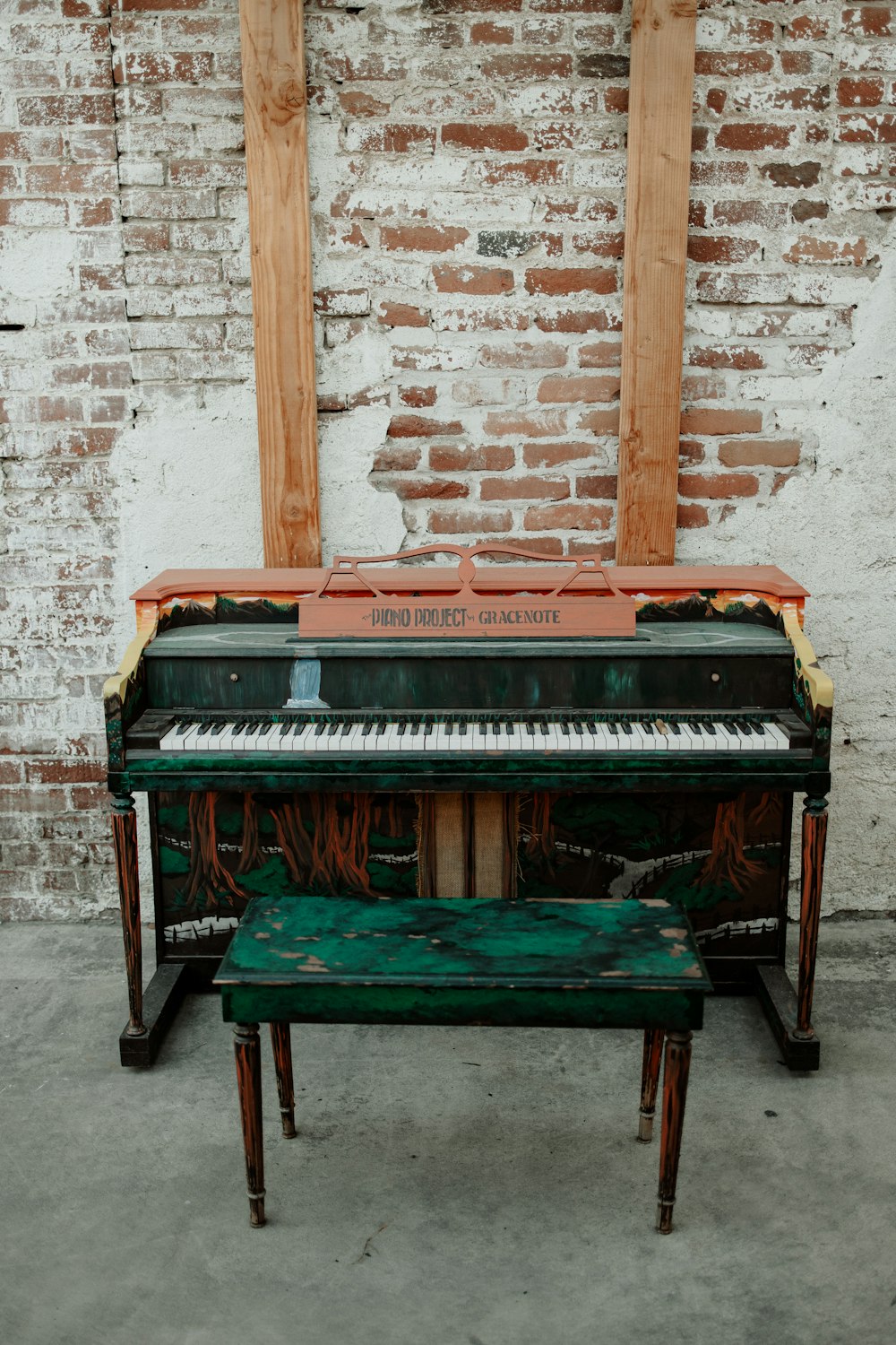 um piano velho sentado em frente a uma parede de tijolos