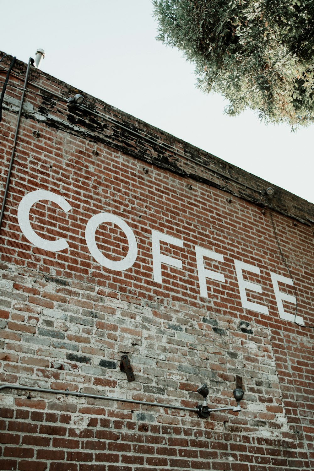 a brick wall with a sign that says coffee on it