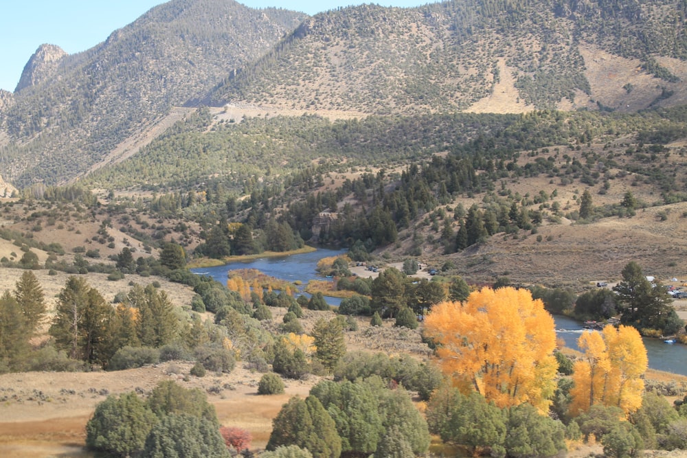 a view of a valley with a river and mountains in the background