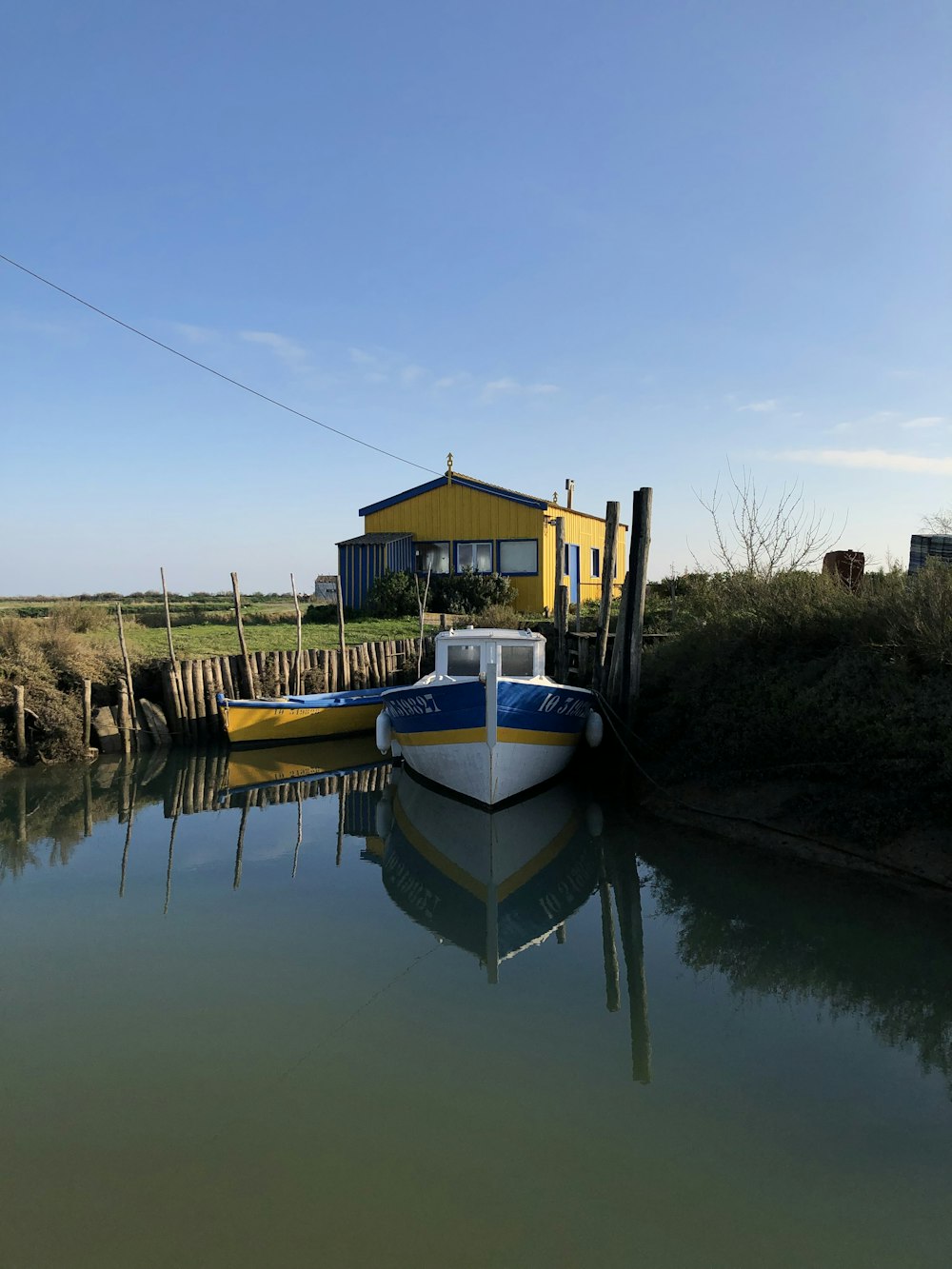 a boat sitting in the water next to a yellow house