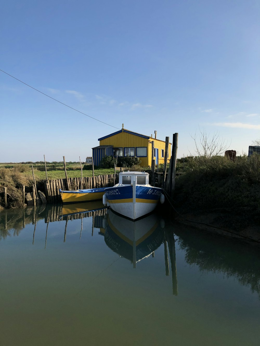 Ein Boot sitzt im Wasser neben einem gelben Haus