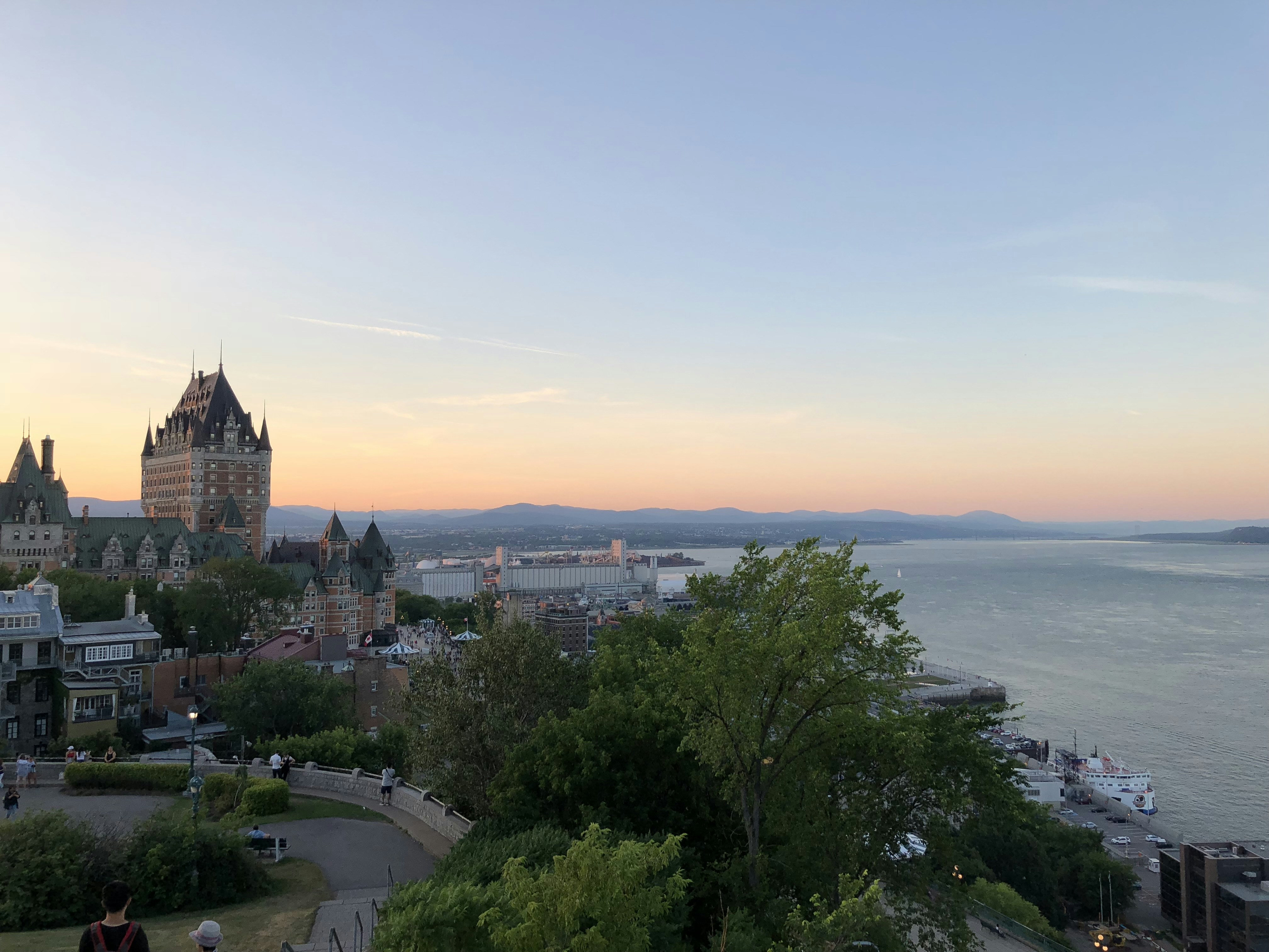 Château Frontenac in Quebec City at dusk, dramatic golden light on stone architecture, deep shadow valleys