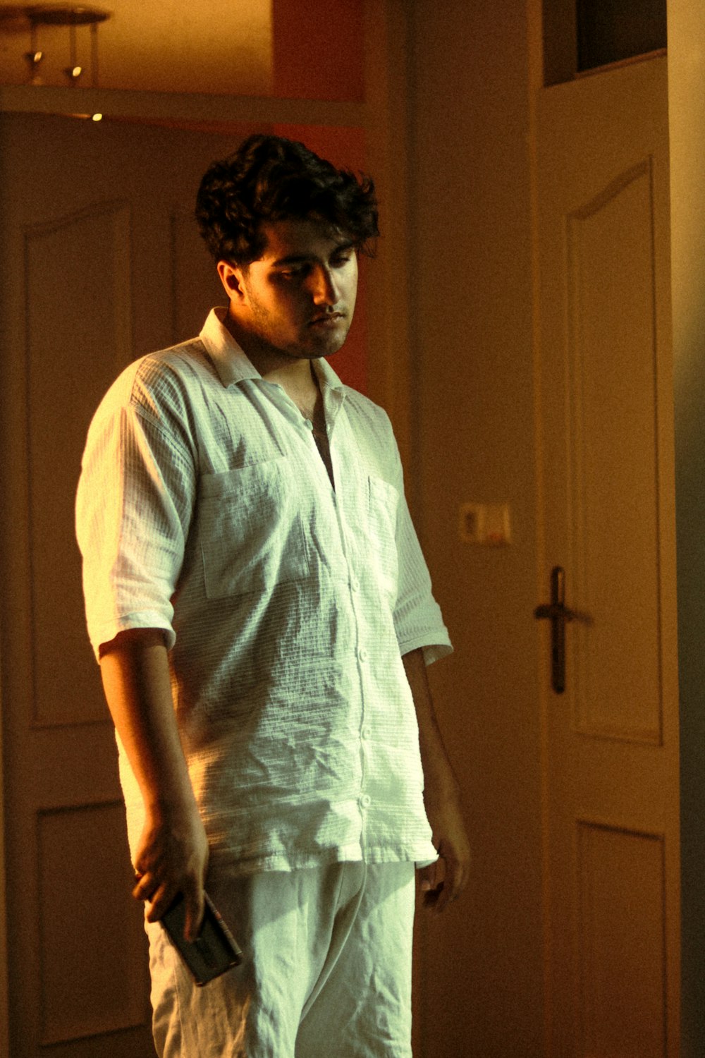 a man in a white shirt and tie standing in a room