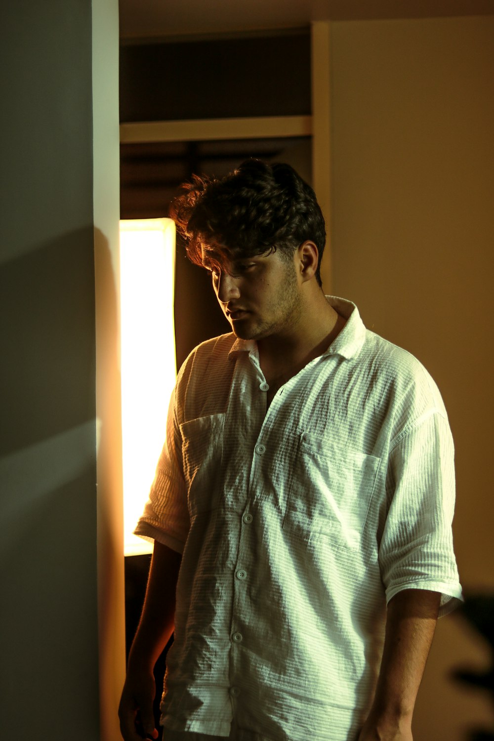a man in a white shirt standing in a doorway