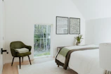 Bedroom with soft linens and a view of the surrounding greenery.