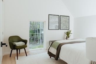 Peaceful bedroom with minimalist decor and large windows overlooking the garden.