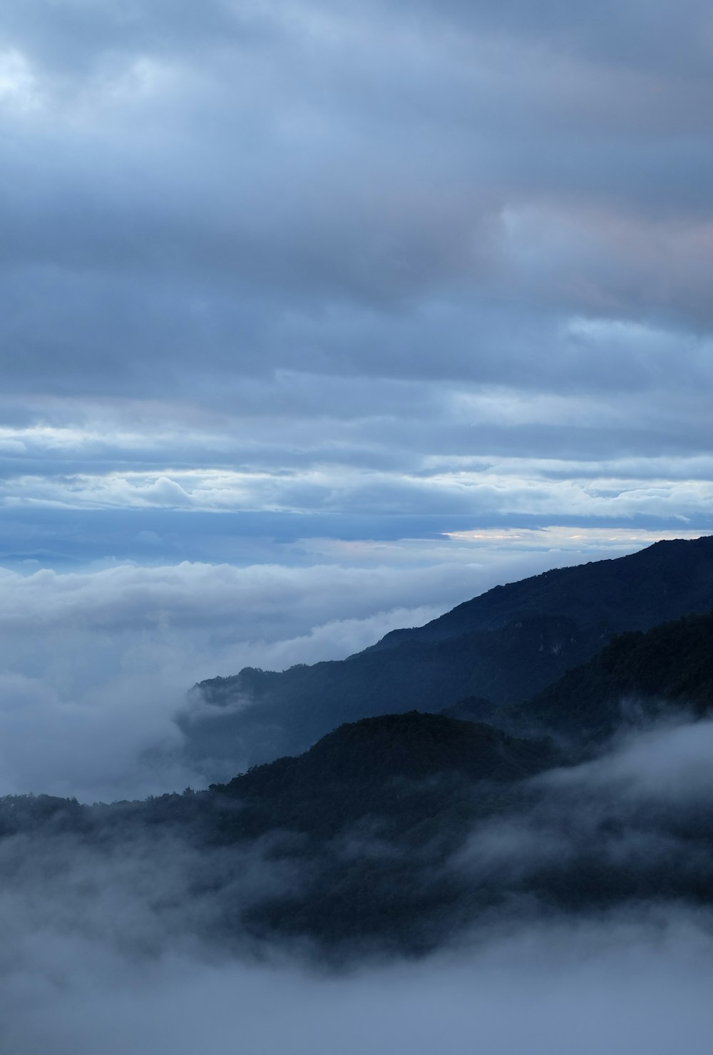 a view of a mountain covered in clouds